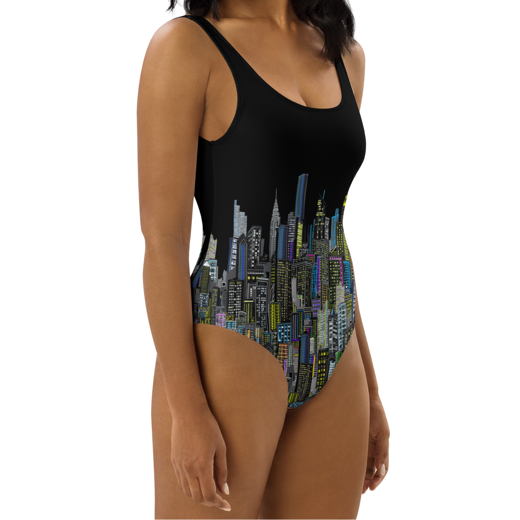 Woman wearing a Loria NYC Art black one-piece swimsuit with city skyline design on a white background