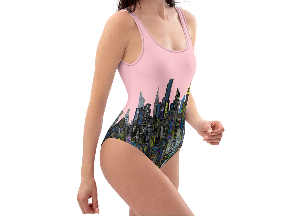 Woman wearing a pink one-piece swimsuit with Loria NYC Art cityscape design on a white background