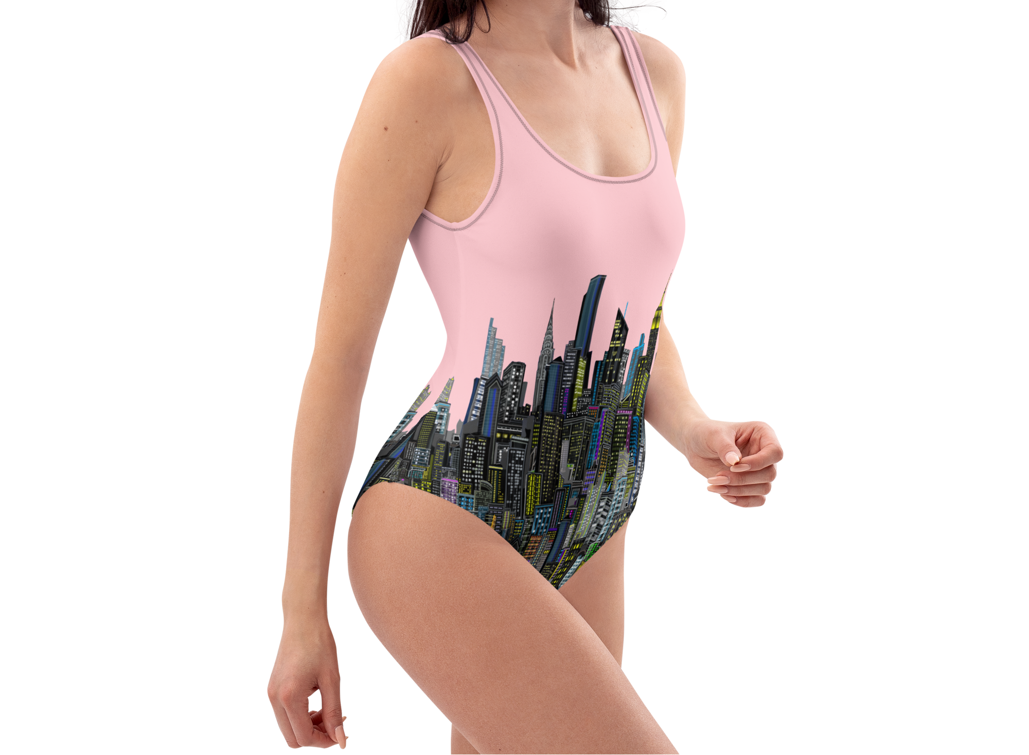 Woman wearing a pink one-piece swimsuit with Loria NYC Art cityscape design on a white background