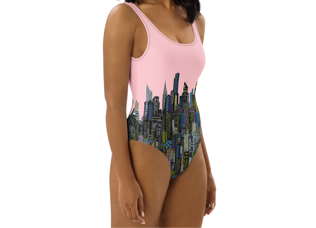 Woman wearing a pink and multicolor cityscape Loria NYC Art one-piece swimsuit on a white background