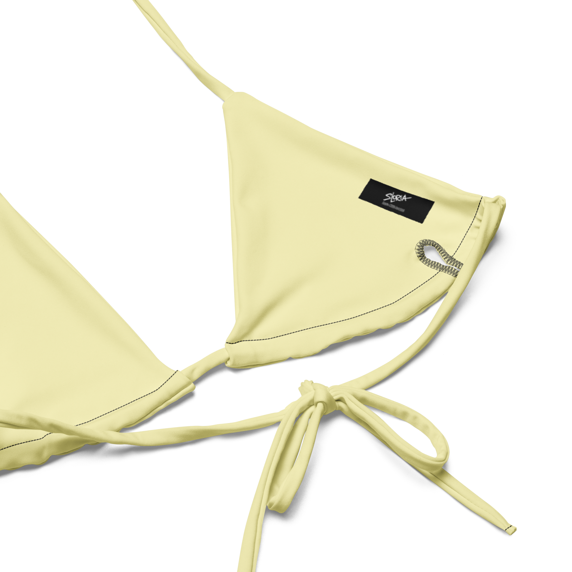 Light yellow bikini top with a Loria NYC Art brand label on a white background