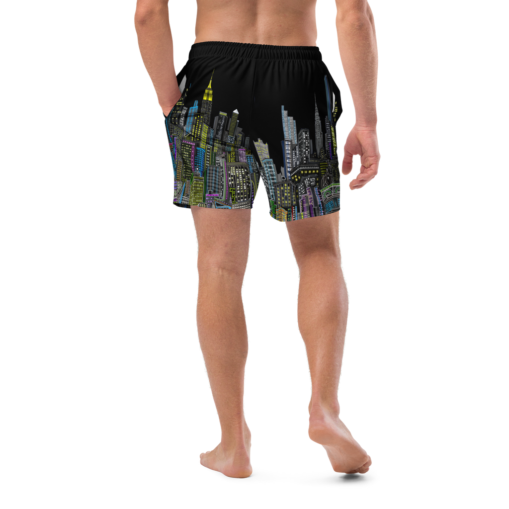 Person wearing black Loria NYC Art swim shorts with colorful cityscape design on a white background