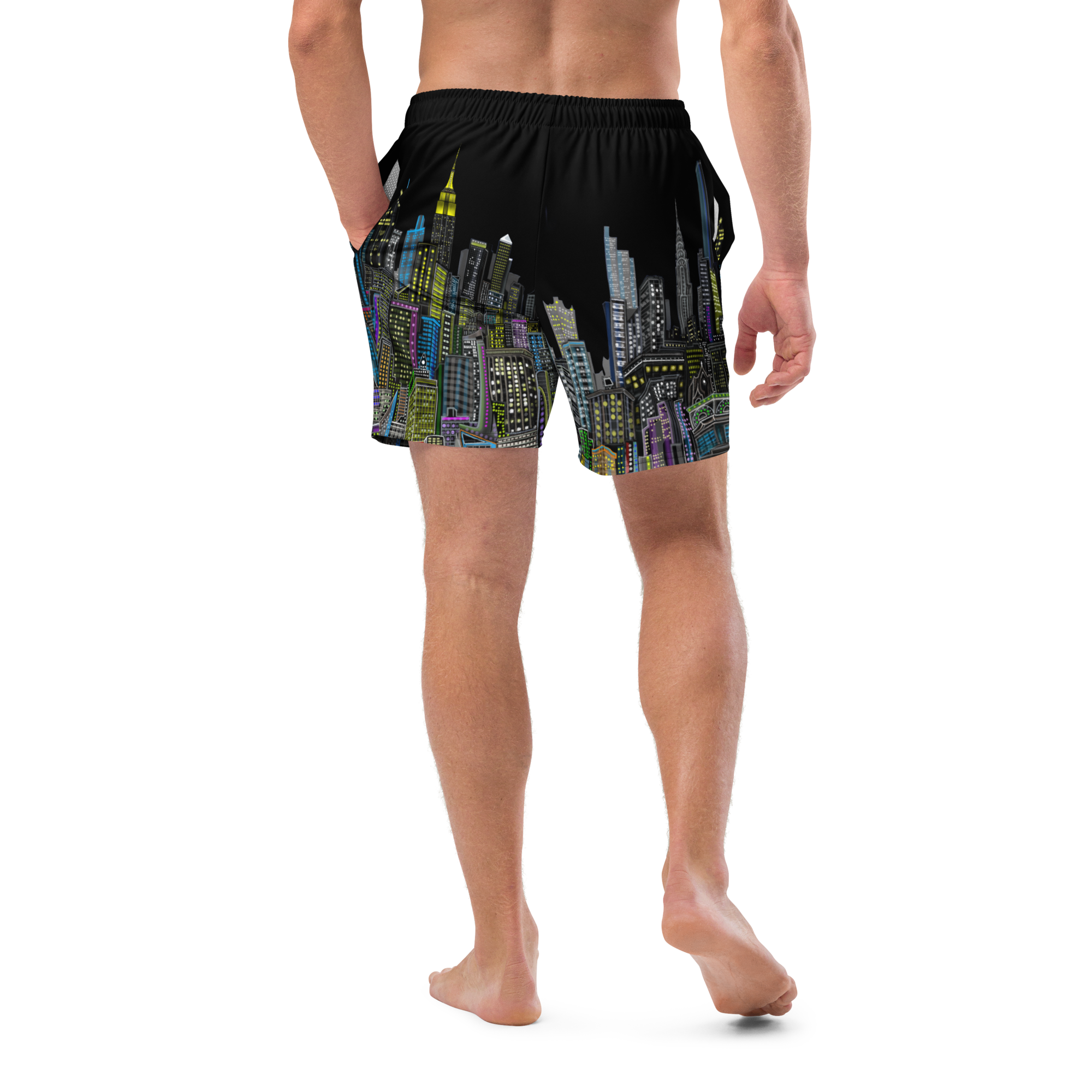Person wearing black Loria NYC Art swim shorts with colorful cityscape design on a white background