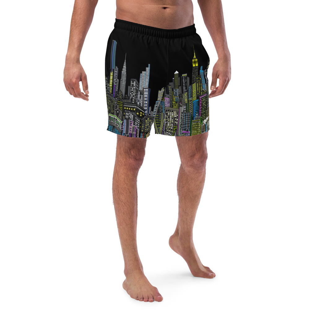 Person wearing black swim shorts with colorful Loria NYC Art cityscape design on a white background