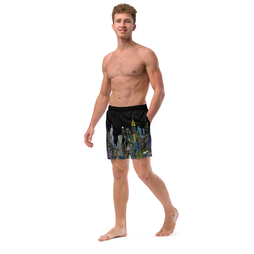 Man wearing black swim shorts with colorful Loria NYC Art cityscape design on a white background