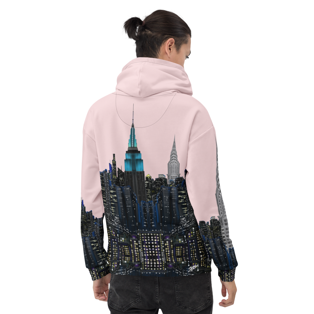 Person wearing a pink hoodie with a cityscape Loria NYC Art design on the back, standing against a white background.