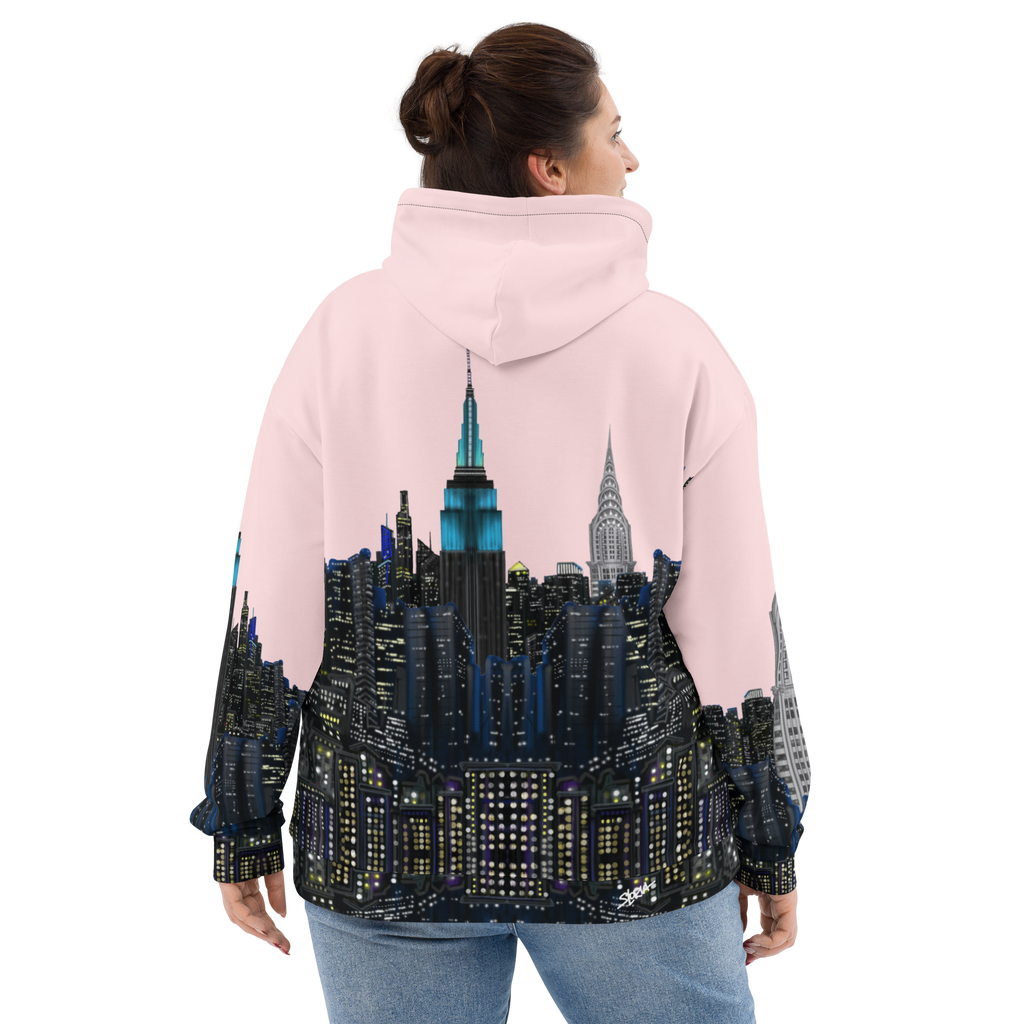 Person wearing a pink Loria NYC Art hoodie with a cityscape design on the back, standing against a white background.