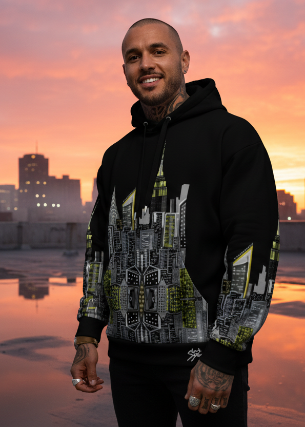 Main in a Sunrise view on a roof wearing a Loria NYC Art hoodie with cityscape design