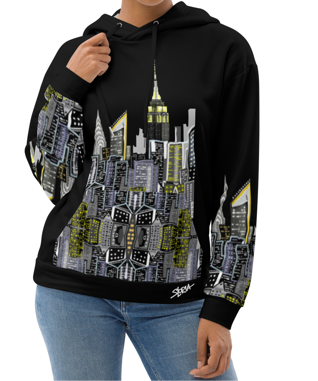 Woman posing in a Loria NYC Art black hoodie with cityscape design on a white background