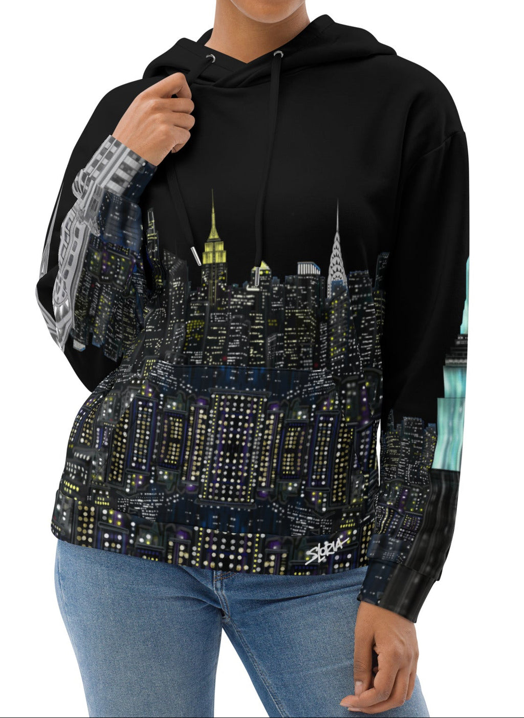 Woman wearing a black Loria NYC Art hoodie with a cityscape design on a white background