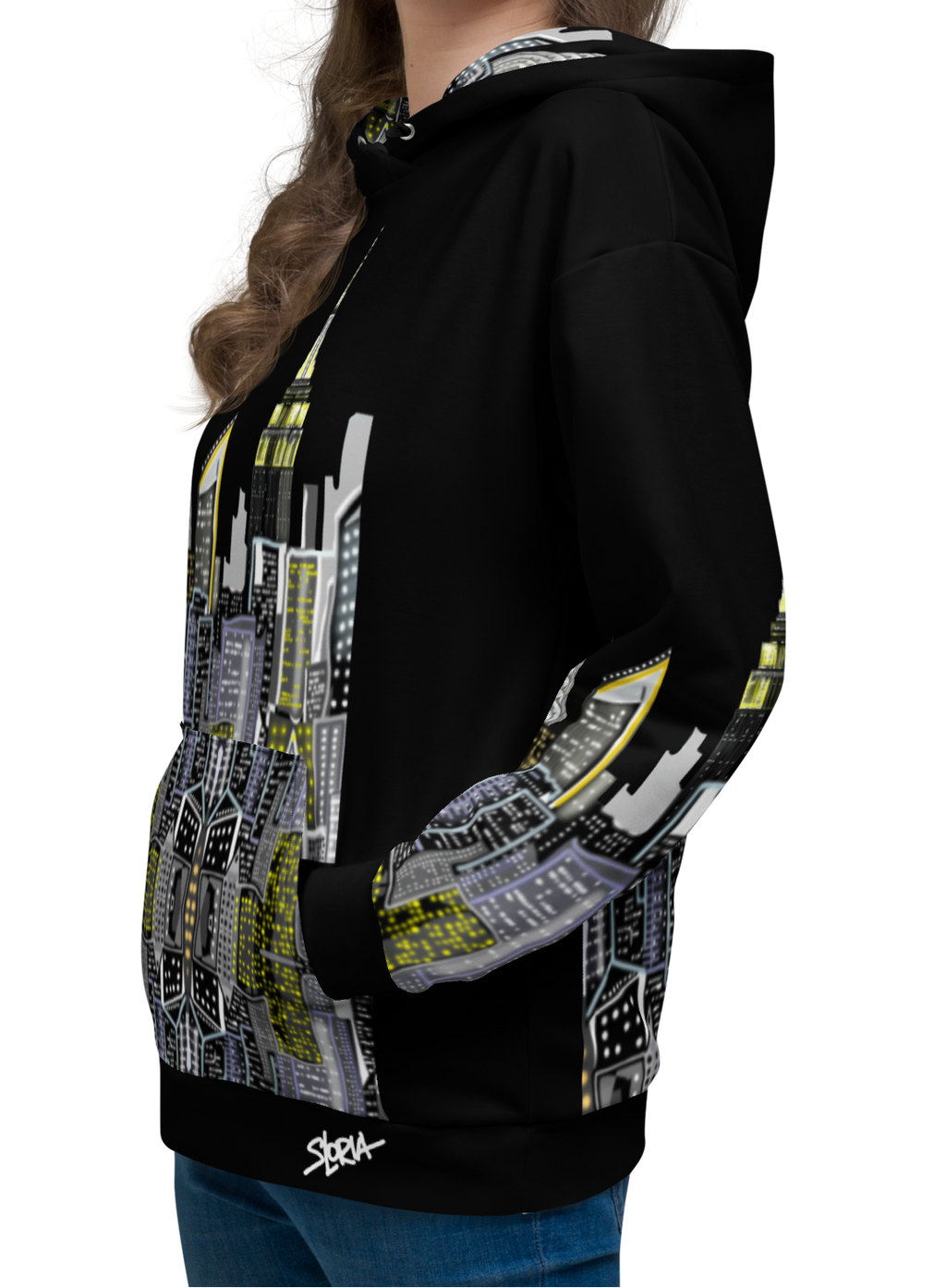 Woman smiling while wearing a Loria NYC Art black hoodie with a cityscape design on a white background