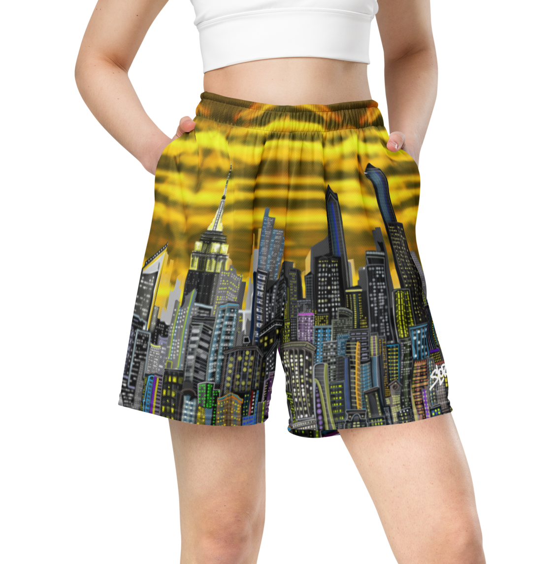 Person wearing a colorful Loria NYC Art cityscape shorts on a white background