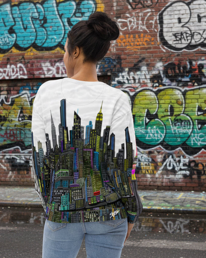 Person wearing a sweater with a cityscape Loria NYC Art design on the back