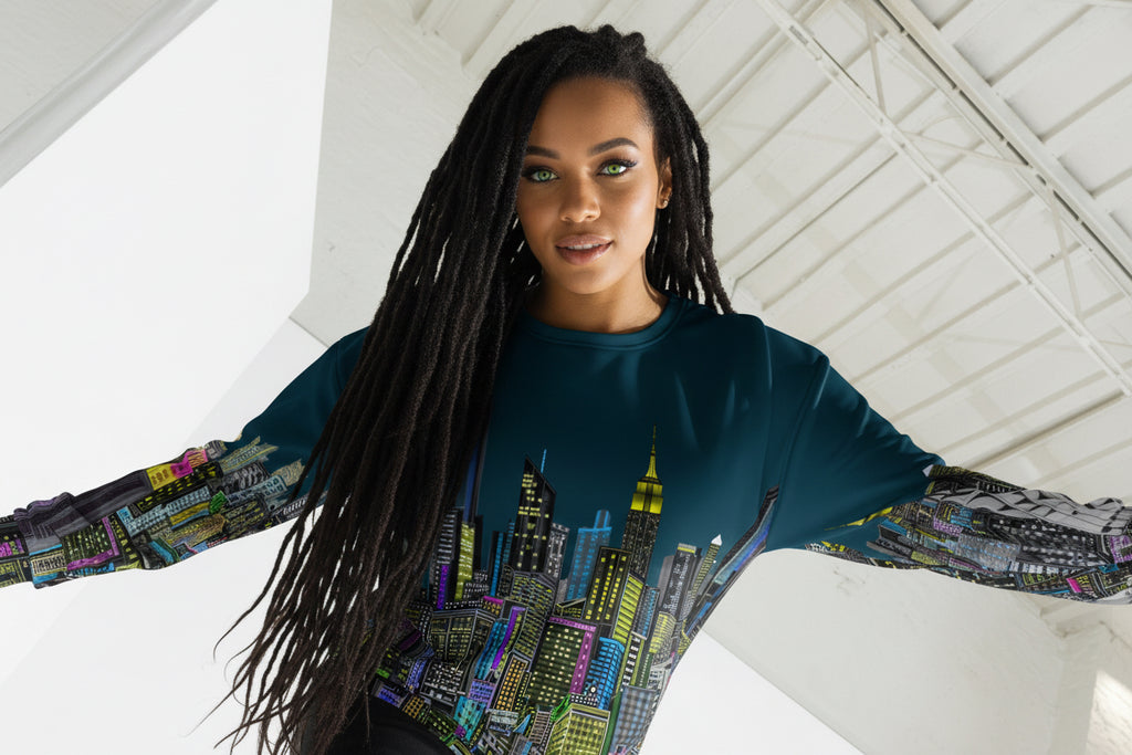 Female wearing a sweater with a colorful cityscape design by Loria NYC Art in a modern indoor setting