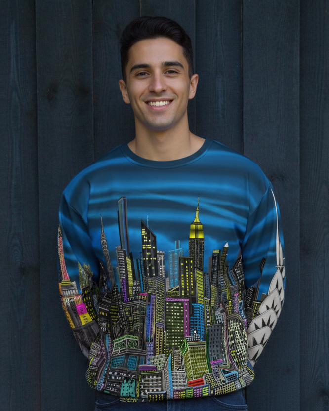Man wearing a colorful cityscape wearing sweatshirt designed by Loria NYC Art on a white against a dark wooden background