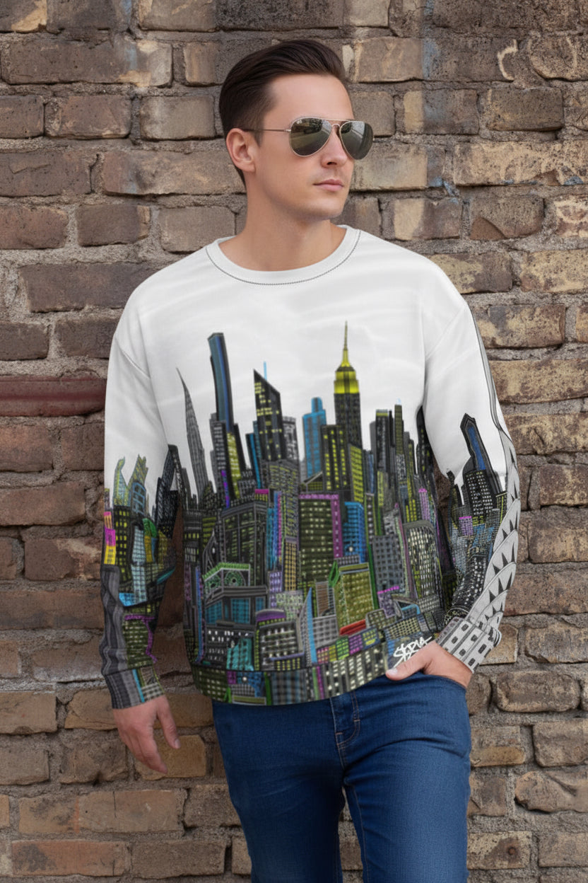 Person wearing a sweater with a cityscape Loria NYC Art design against a brick wall.