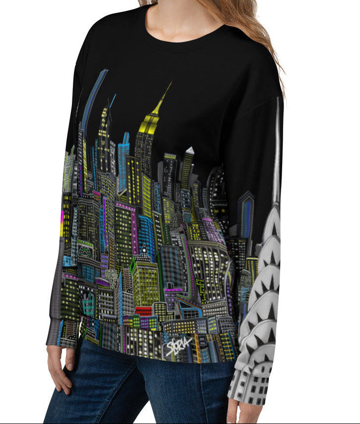 Girl modeling a black sweatshirt with a colorful cityscape design by Loria NYC Art on a white background