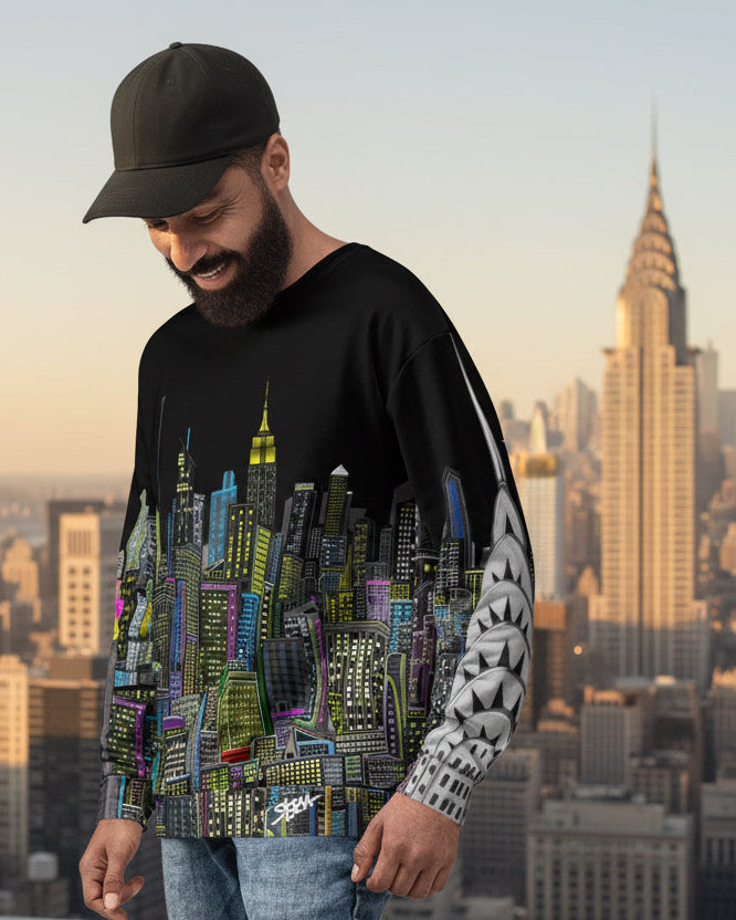 Man wearing a black sweatshirt with a colorful Loria NYC Art cityscape design in front of a city skyline.