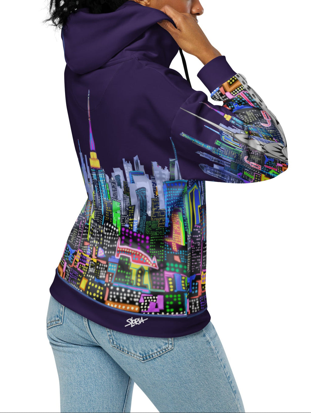 Person wearing a Loria NYC Art hoodie with a colorful cityscape design on a white background