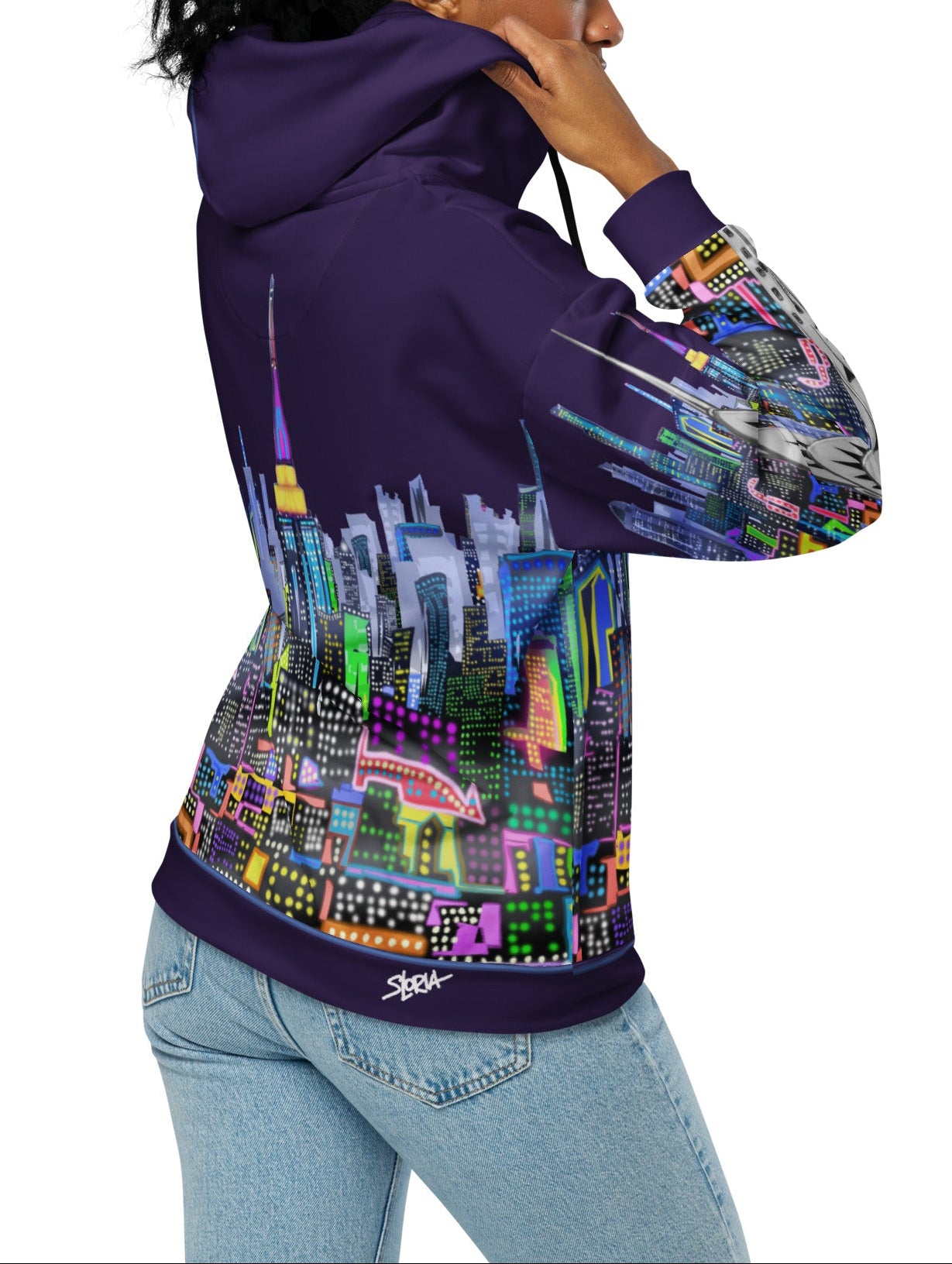 Person wearing a Loria NYC Art hoodie with a colorful cityscape design on a white background