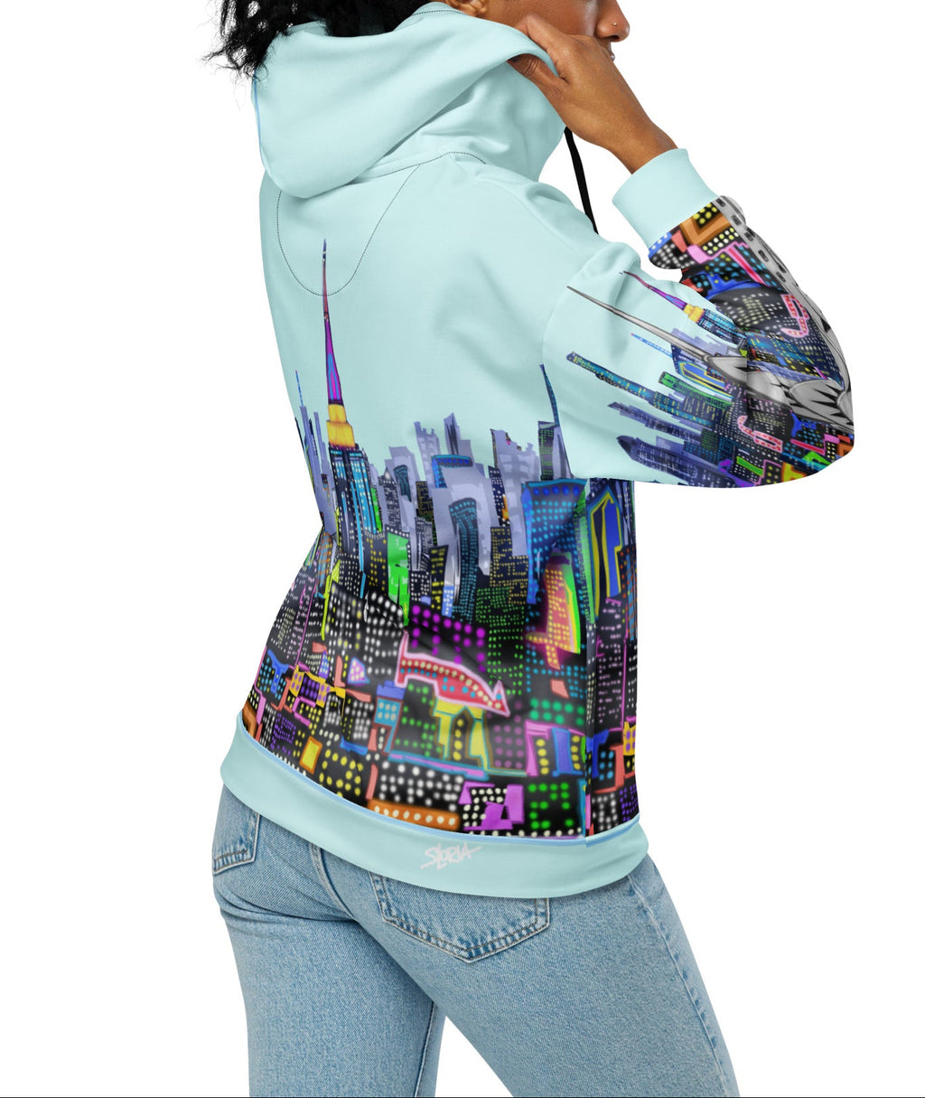 Person wearing a light blue hoodie with a colorful cityscape Loria NYC Art design on the back, on a white background.