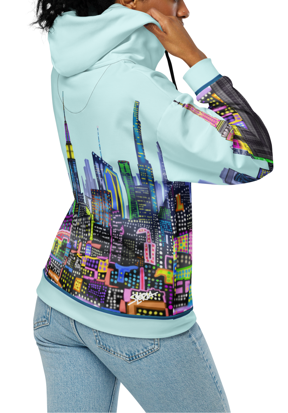Person wearing a light blue hoodie with colorful Loria NYC Art cityscape design on the back, standing against a white background.