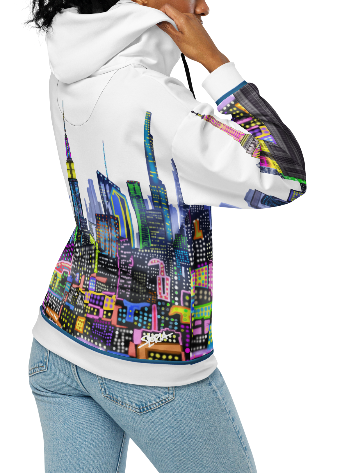 Person wearing a white hoodie with colorful cityscape Loria NYC Art design on the back, standing against a white background.