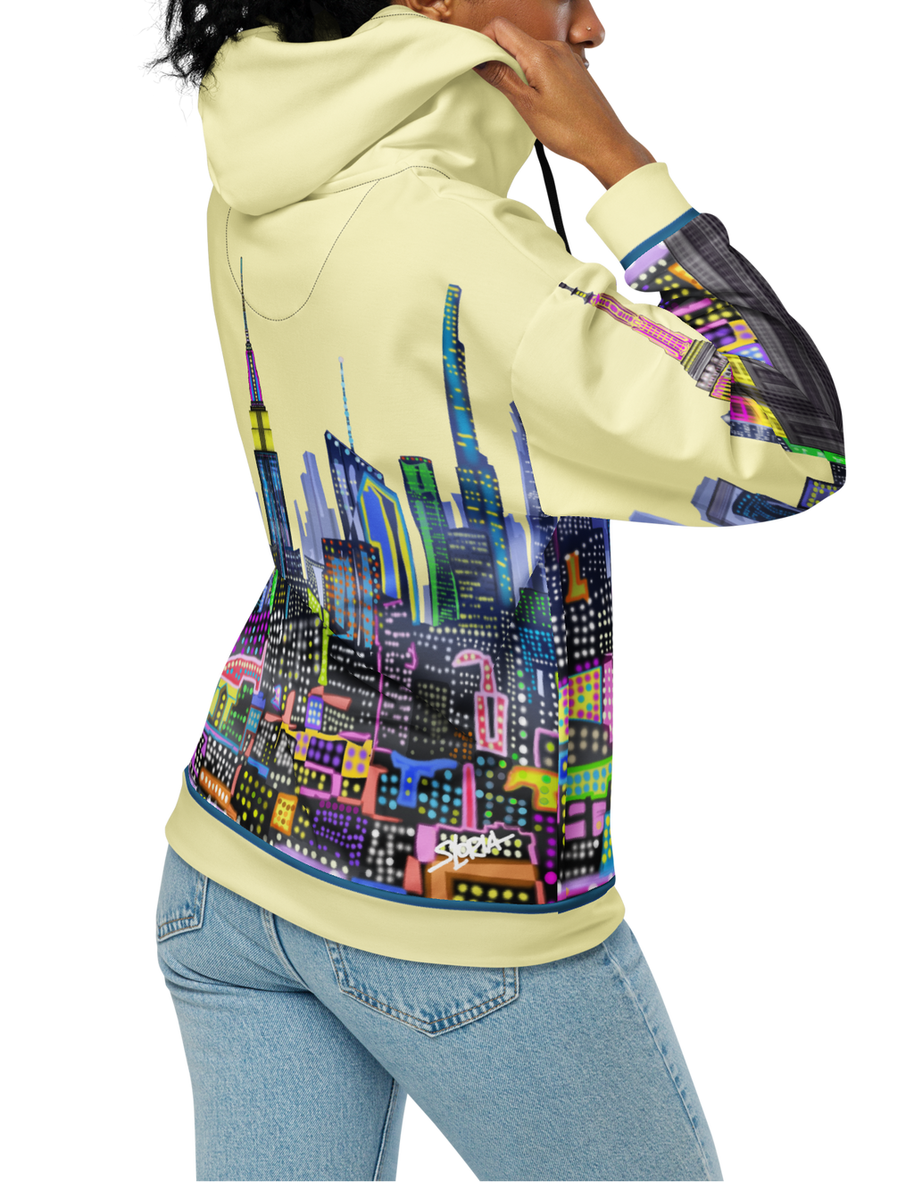 Person wearing a hoodie with a Loria NYC Art colorful cityscape design on the back, standing against a white background.