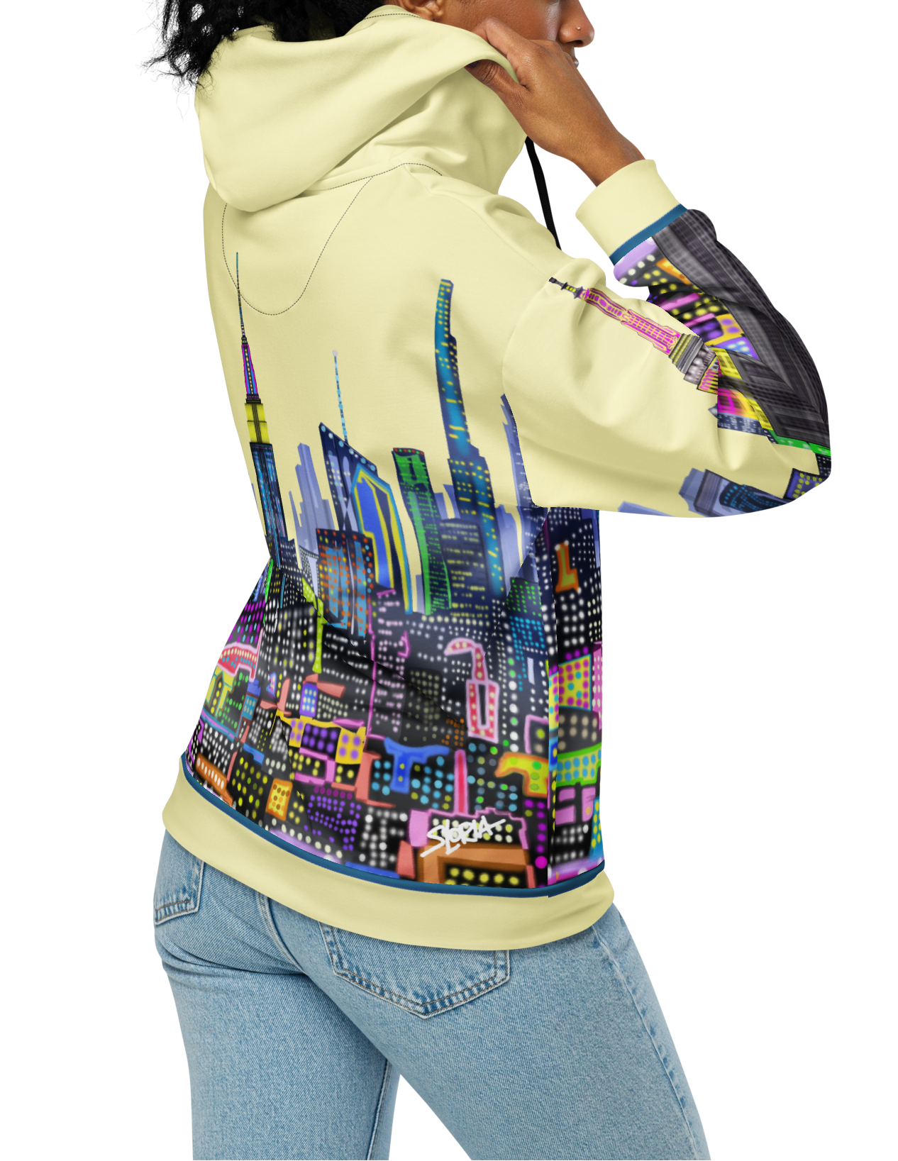 Person wearing a hoodie with a Loria NYC Art colorful cityscape design on the back, standing against a white background.
