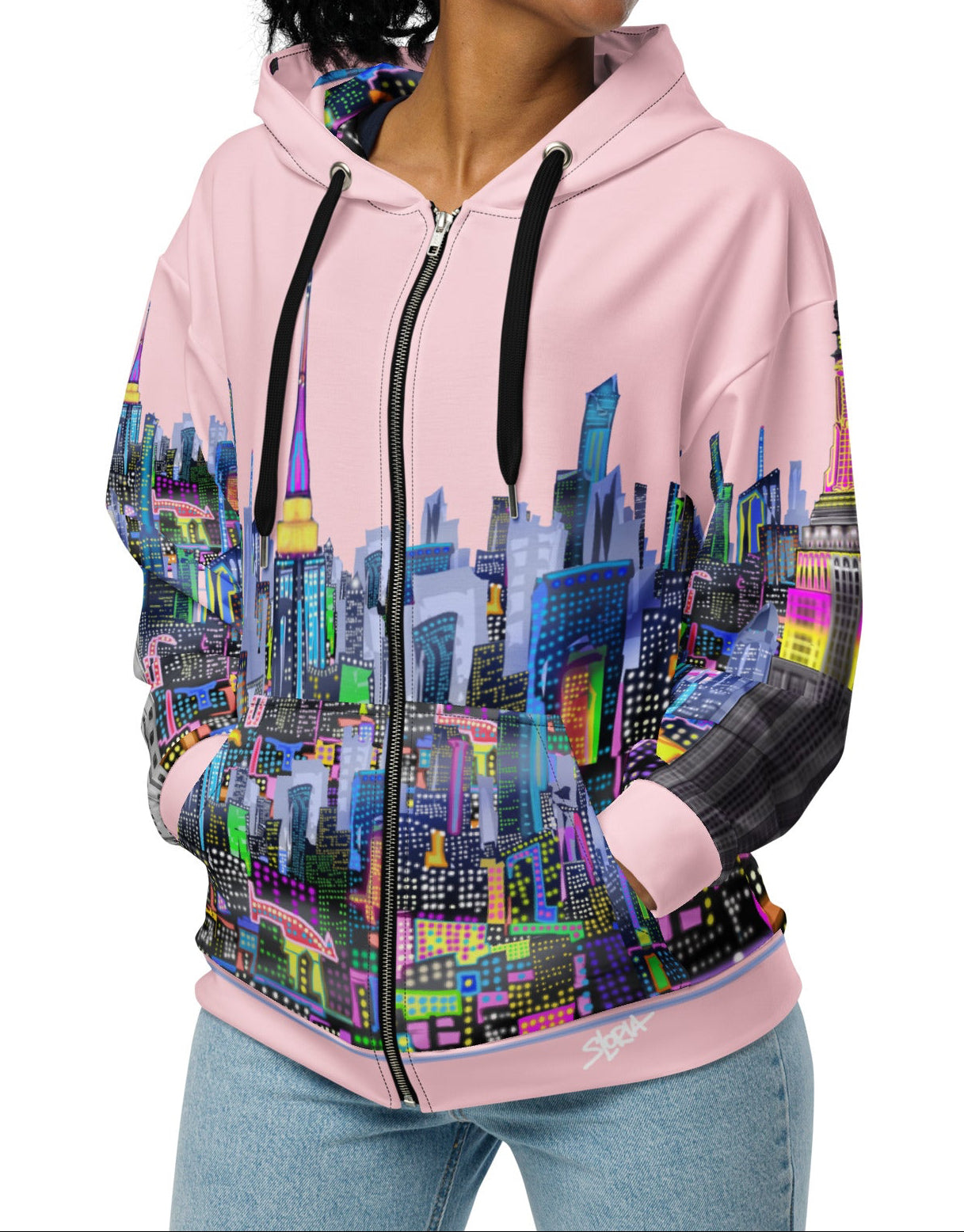 Person wearing a pink hoodie with a colorful cityscape Loria NYC Art design on a white background