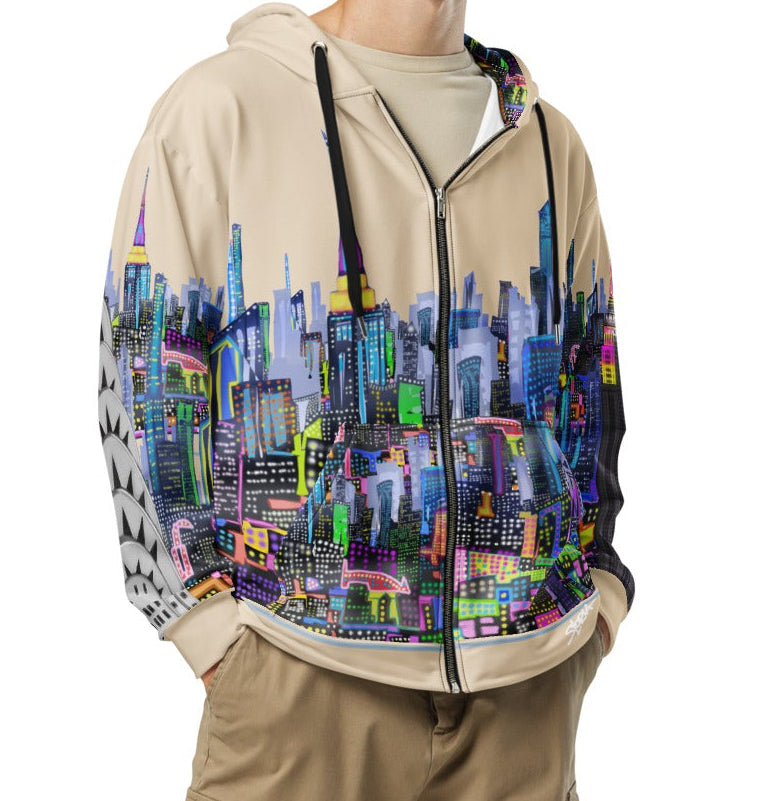 Person wearing a colorful Loria NYC Art hoodie with a cityscape design and beige pants on a white background