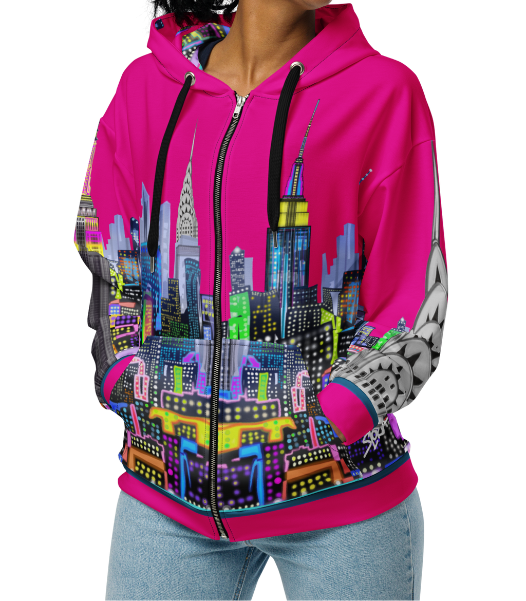 Woman wearing a Loria NYC Art hoodie with a colorful cityscape design on a white background