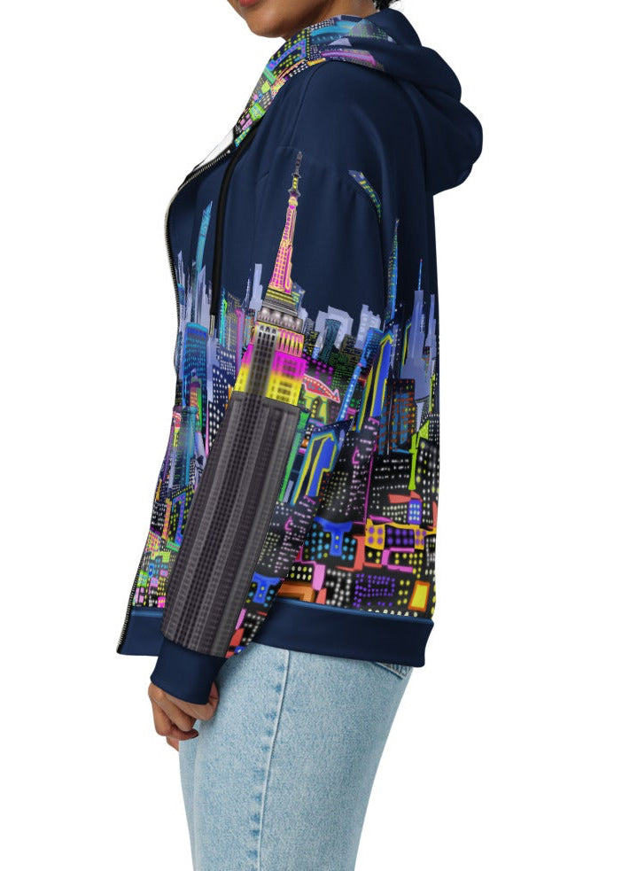 Person wearing a colorful hoodie with a cityscape design by Loria NYC Art on a white background