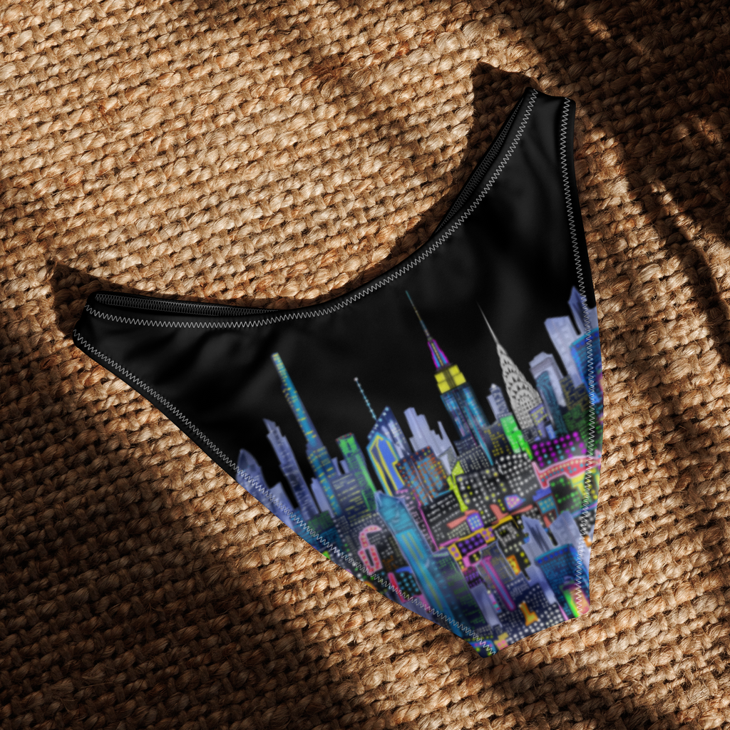 Black swimsuit bottom with colorful cityscape Loria NYC Art design on a textured surface