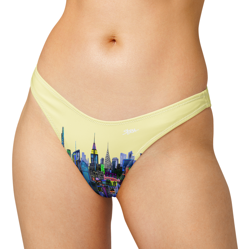 Yellow bikini bottom with Loria NYC Art cityscape design on a white background