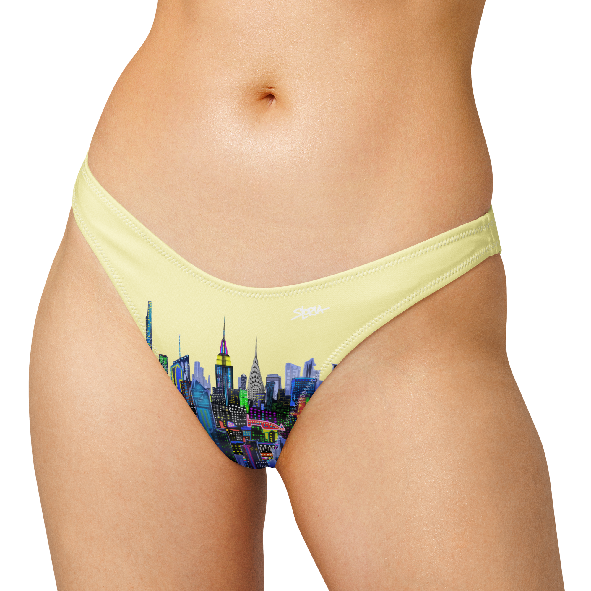 Yellow bikini bottom with Loria NYC Art cityscape design on a white background