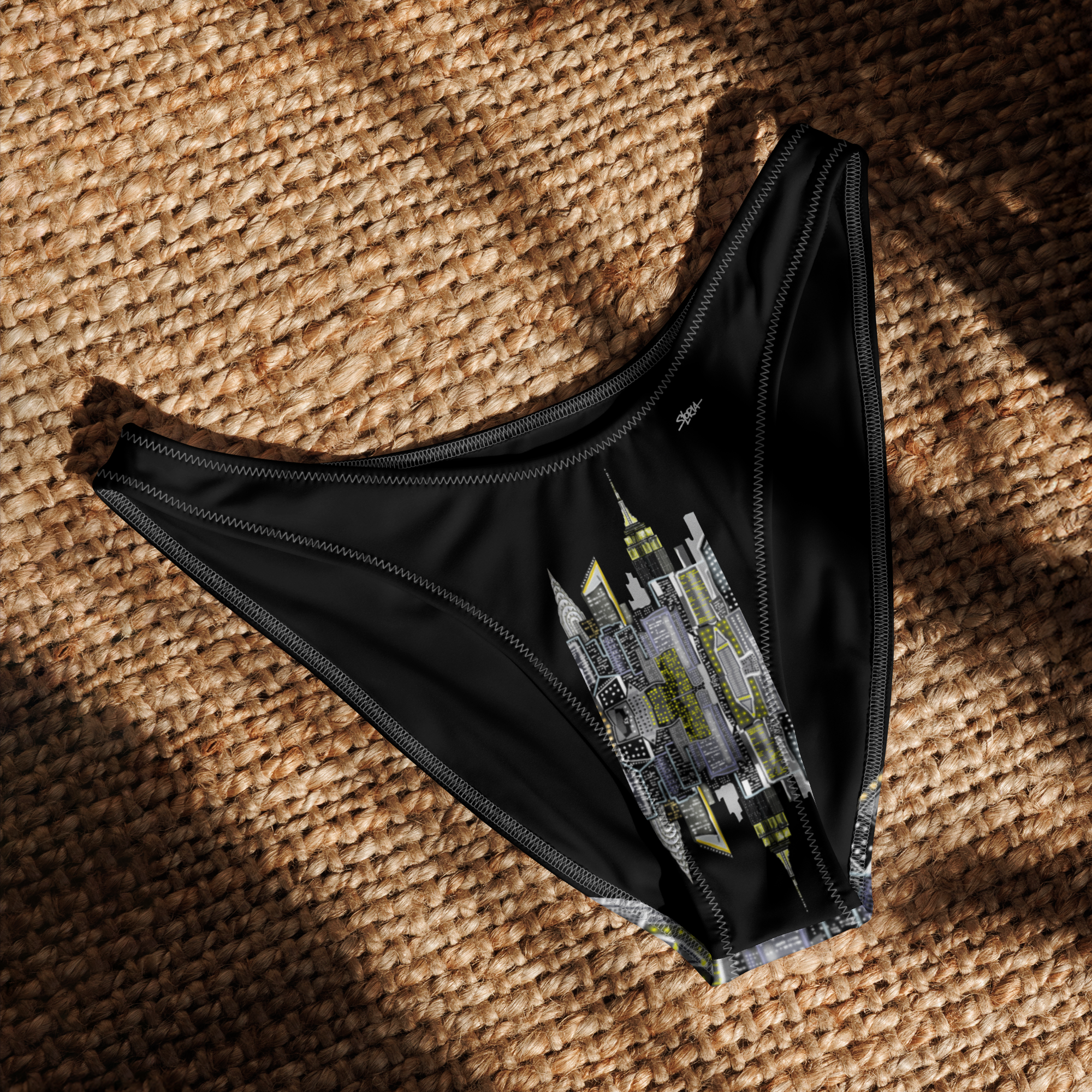 Black underwear with Loria NYC Art design on a textured brown surface