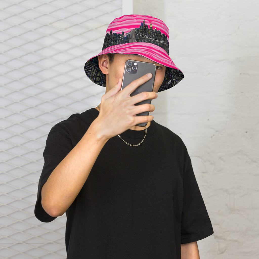 Man posing in a  Reversible Bucket Hat with Città Rosa Vento Fuchsia NYC skyline designed with Brooklyn bridge by S.Loria NYC