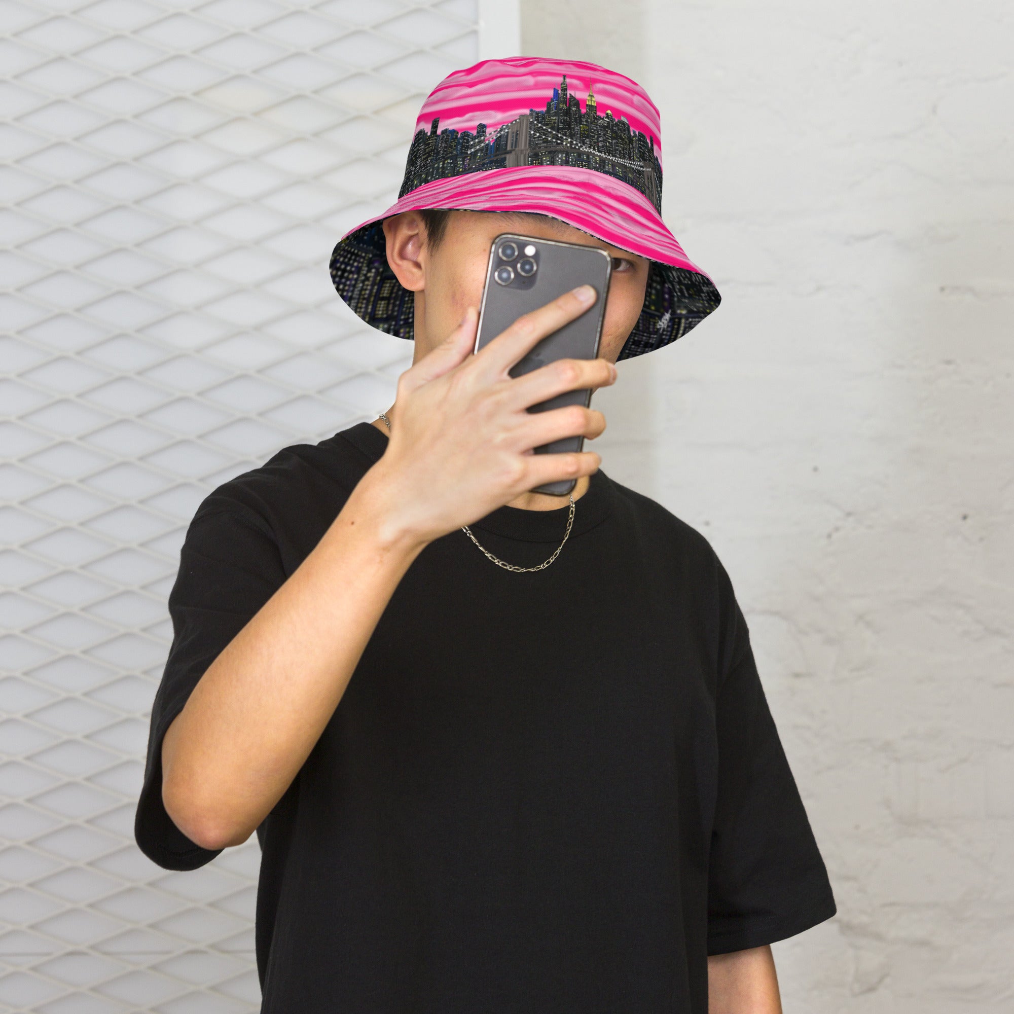 Man posing in a  Reversible Bucket Hat with Città Rosa Vento Fuchsia NYC skyline designed with Brooklyn bridge by S.Loria NYC