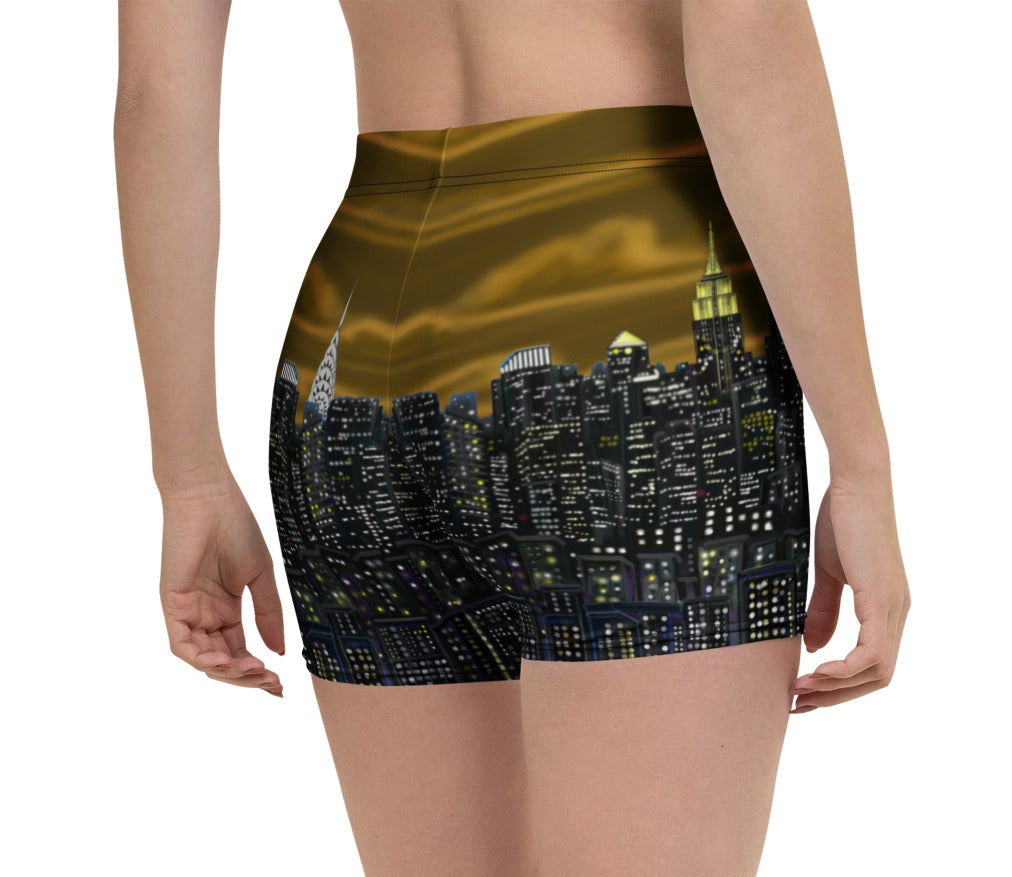 Person wearing Loria NYC Art brown black shorts with a cityscape design on a white background