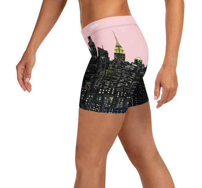 Person wearing a pair of pink shorts with a Loria NYC Art skyline design on a white background
