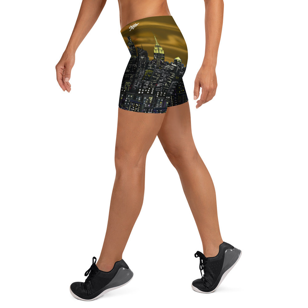 Person wearing Loria NYC Art shorts with a cityscape design on a white background