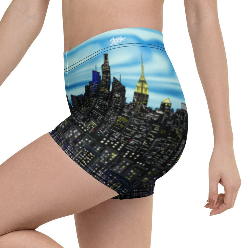 Person wearing a pair of shorts with a cityscape Loria NYC Art design on a white background