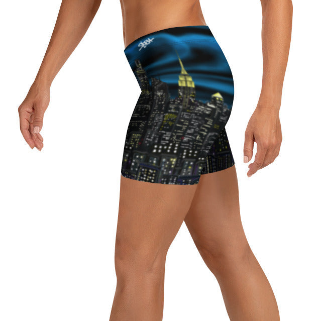 Person wearing Loria NYC Art shorts with a cityscape design on a white background
