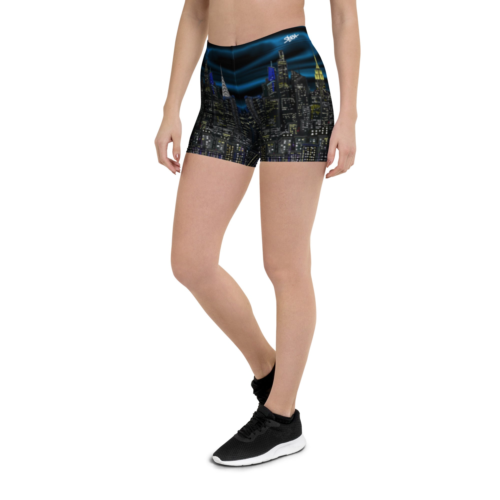 Person wearing Loria NYC Art shorts with a cityscape design on a white background