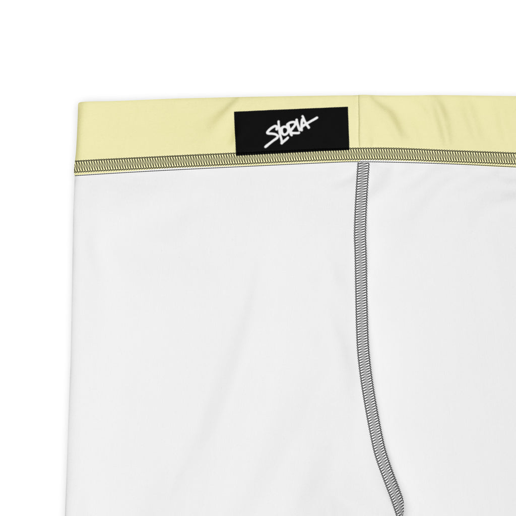 Athletic shorts  with a yellow waistband and black brand label on a white background 