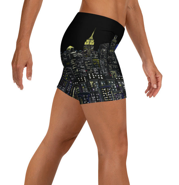 Person wearing black Loria NYC Art athletic shorts with a cityscape design on a white background
