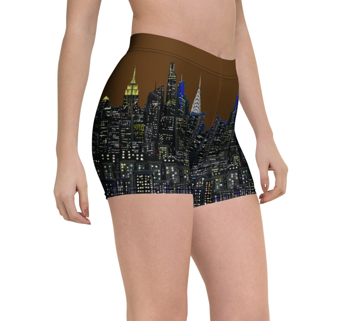 Person wearing Loria NYC Art shorts with a cityscape design on a white background