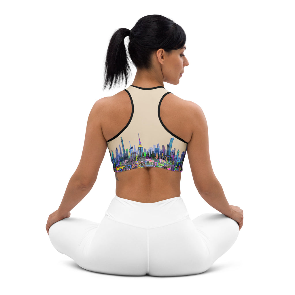 Girl wearing Sports bra with colorful cityscape design on a beige background designed by Loria NYC Art 