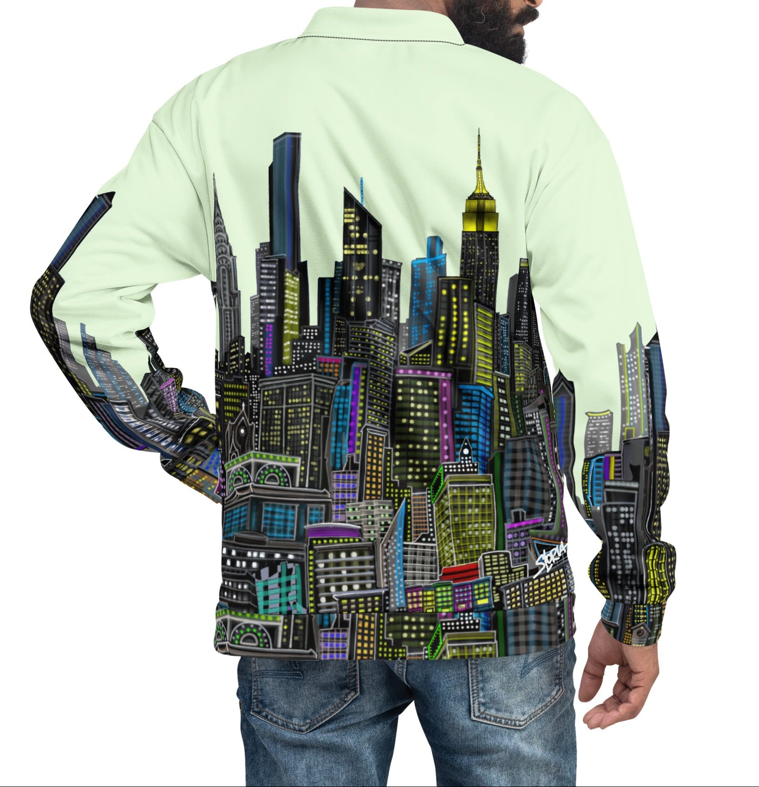 Person wearing a light green Loria NYC Art jacket with a colorful cityscape design on the back, standing against a white background.